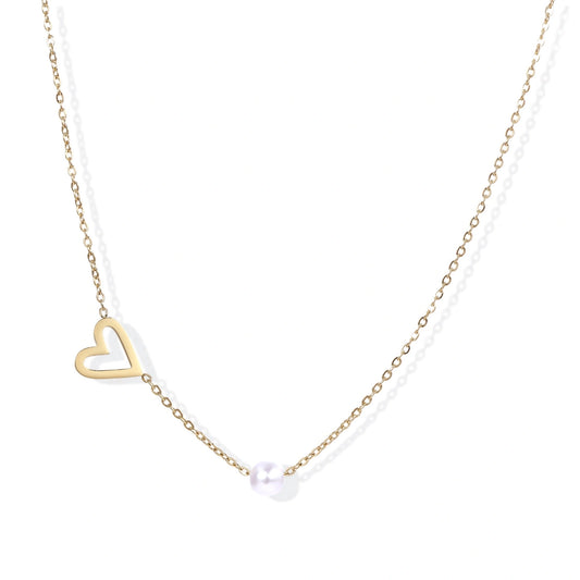 Delicate gold necklace with open heart charm and white pearl bead on fine chain against cream background