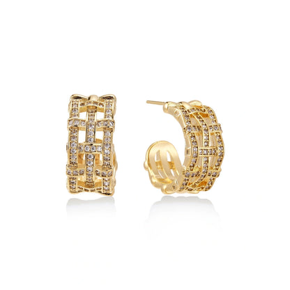 Gold-plated geometric hoop earrings with basket-weave lattice design and pavé crystal accents on cream background