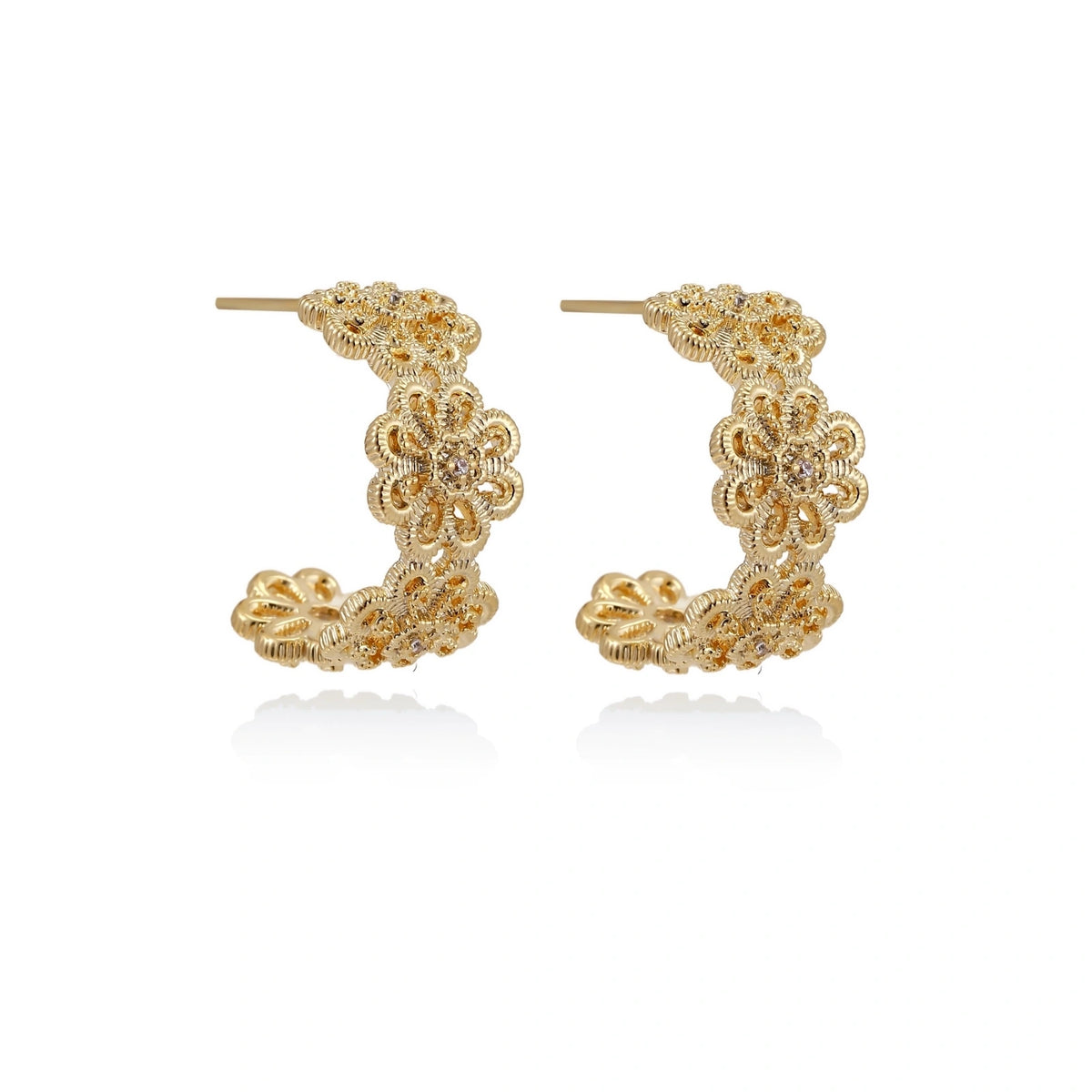 Gold hoop earrings with intricate three-dimensional floral filigree pattern in 14K gold plated brass on cream background