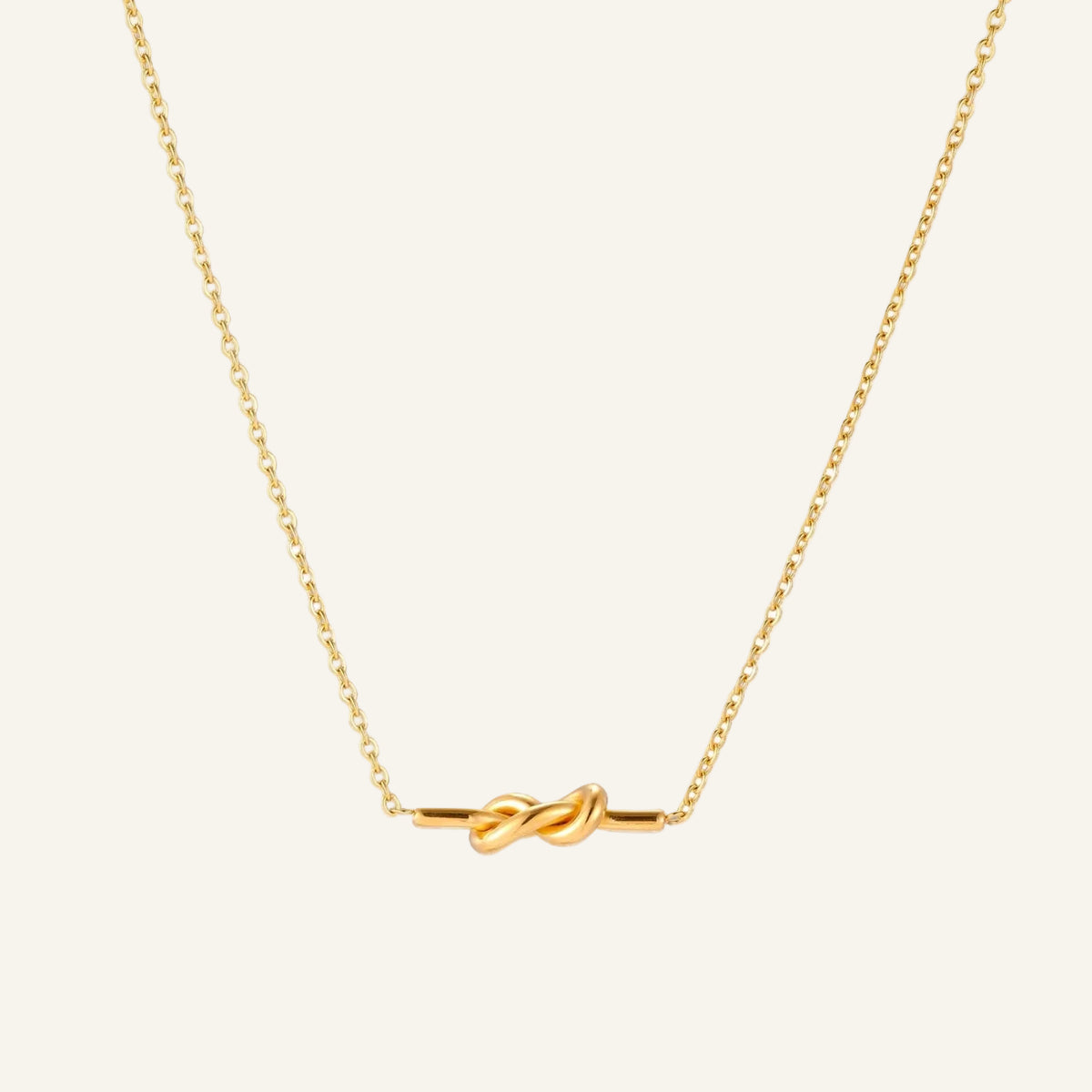 Dainty 18K gold plated necklace with infinity knot pendant on delicate chain against white background