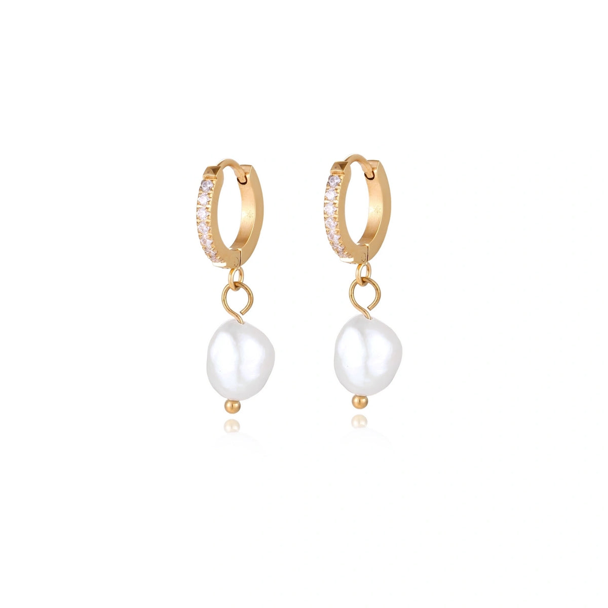 Gold huggie hoop earrings with pavé crystals and white freshwater pearl drops on cream background