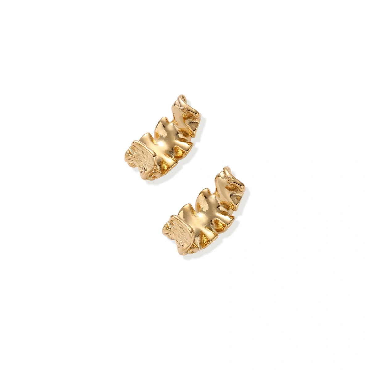 Pair of gold huggie hoops with sculpted wave texture and dimensional ripples on neutral background.