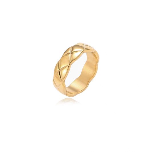 Close-up of an 18K gold-plated twisted band ring with dimensional braided pattern on cream background.