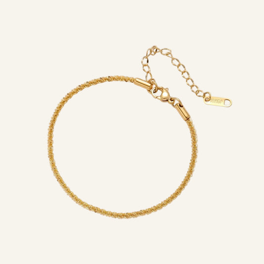 Delicate 18K gold-plated stainless steel bracelet with textured beaded chain on cream background