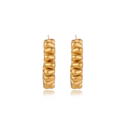 Sculptural gold-plated hoop earrings with continuous twisted spiral design on cream background