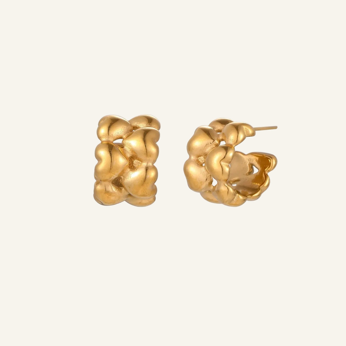 Close-up of gold-plated twisted rope huggie hoop earrings with brushed finish on white background.