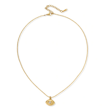 Layered necklace with green stone beads, gold spacers, white accents, and protective eye pendant on cream background.