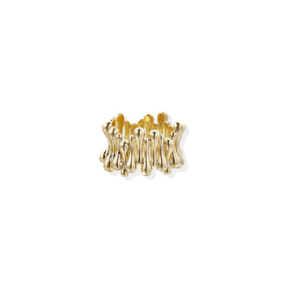 Gold-plated brass ring with sculptural petal-like elements in a wide band design on beige background