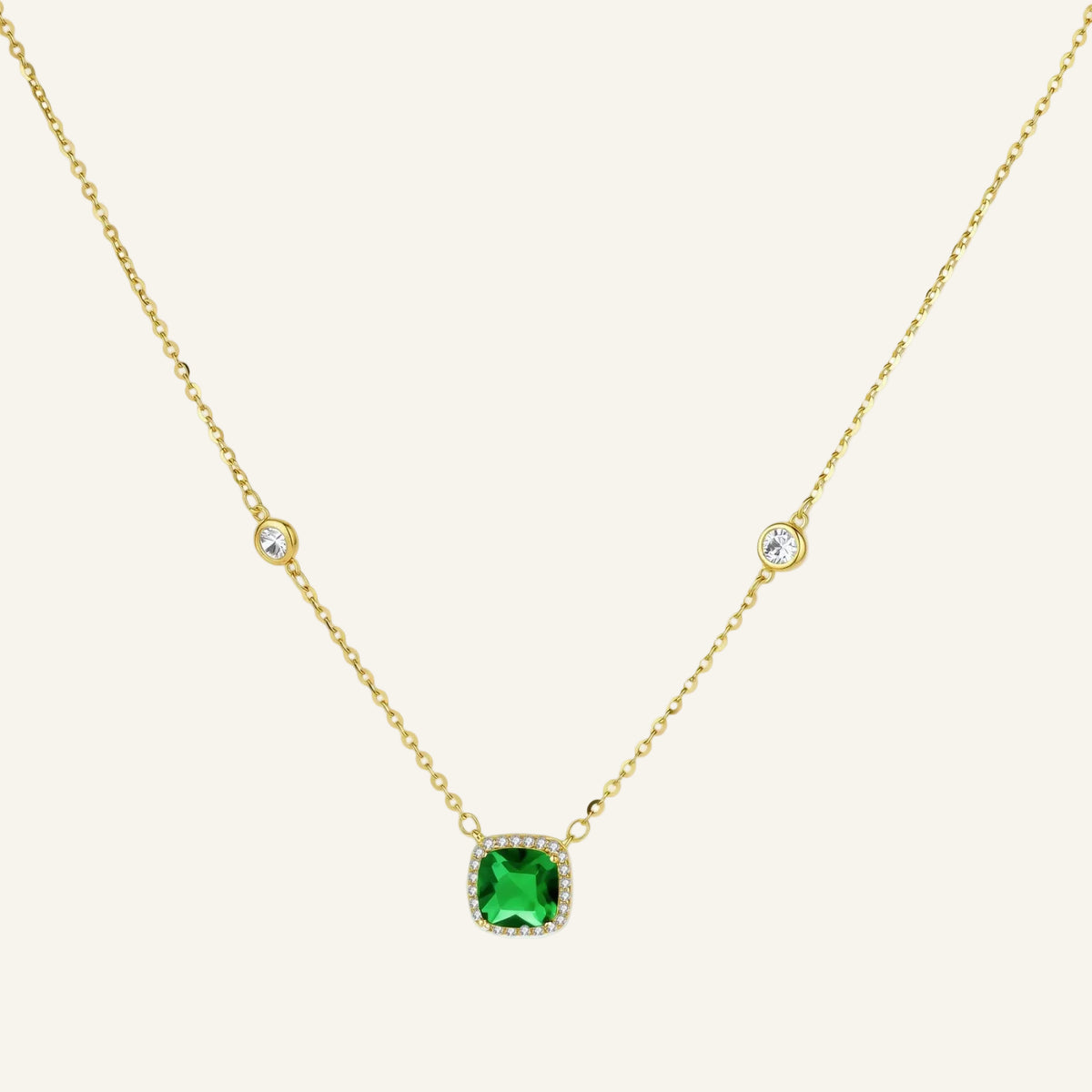 Delicate gold chain necklace featuring square emerald pendant with crystal halo and station accents