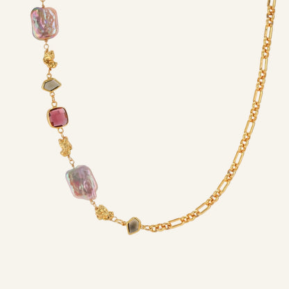 18k gold-plated chain necklace with iridescent baroque pearls and burgundy gemstones on white background.